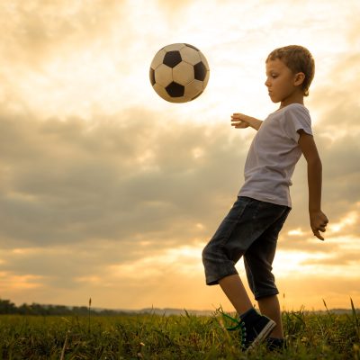 Young little boy playing in the field with soccer ball. Young little boy playing in the field with soccer ball.